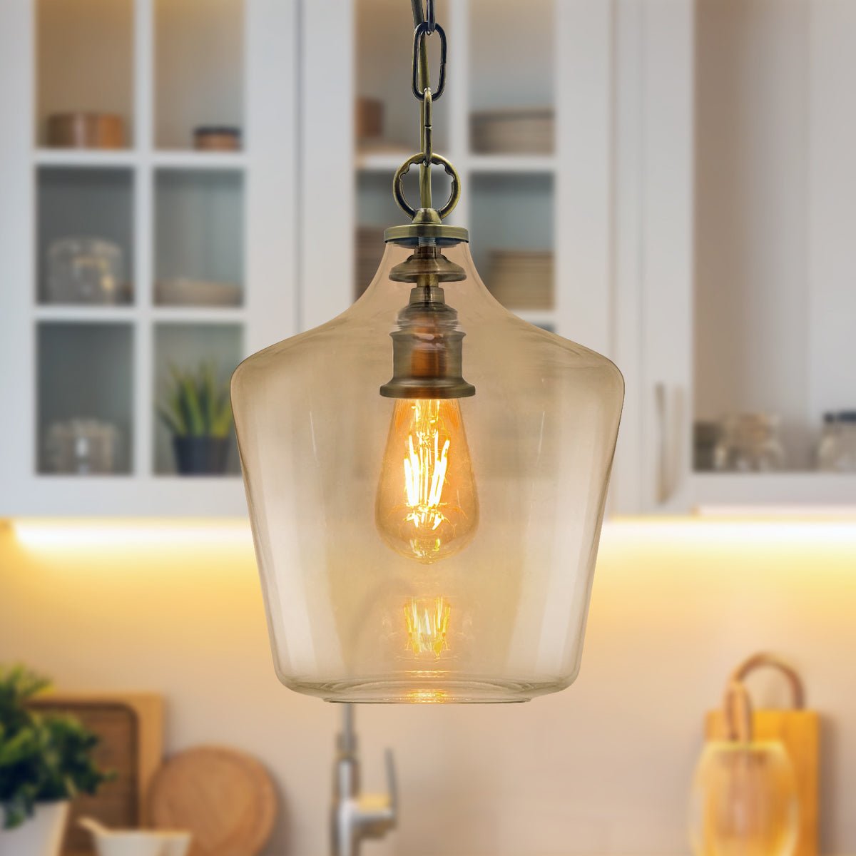 Traditional antique brass hanging ceiling light with a transparent glass shade and single-lamp design
